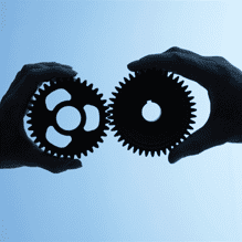 Two hands holding two gears on a blue background.